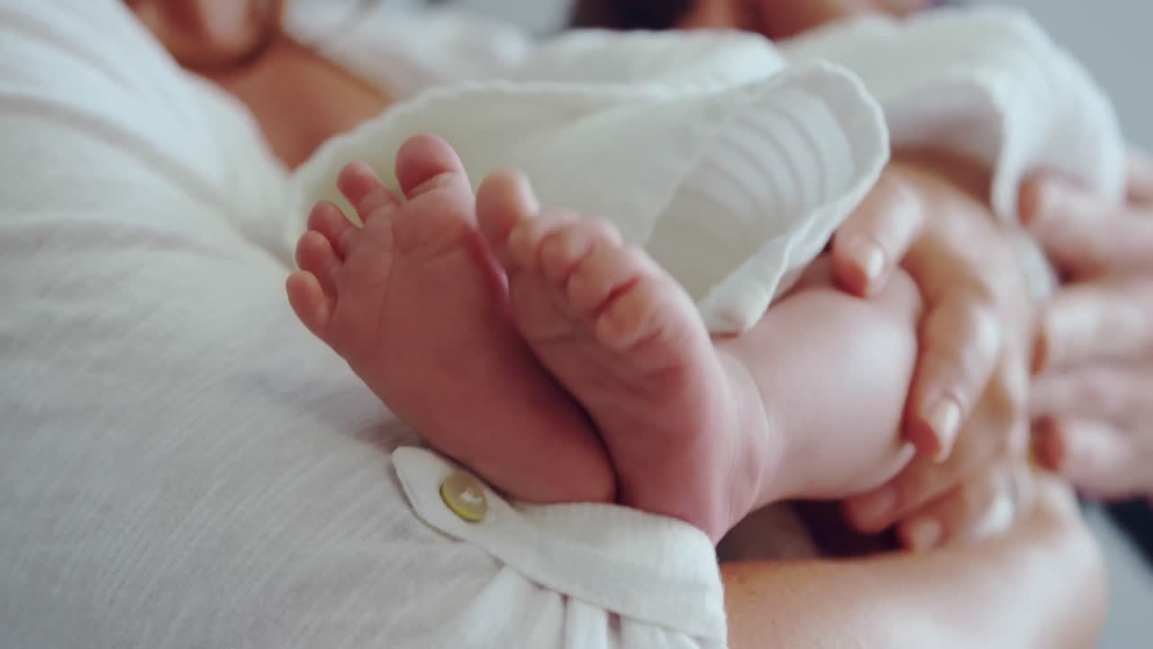 Primer plano de una madre caucásica sosteniendo a su bebé recién nacido en la sala del hospital