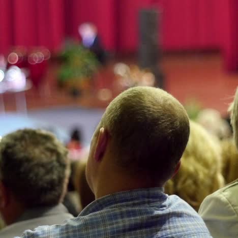 crowd of people to sitting and listening in a large hall