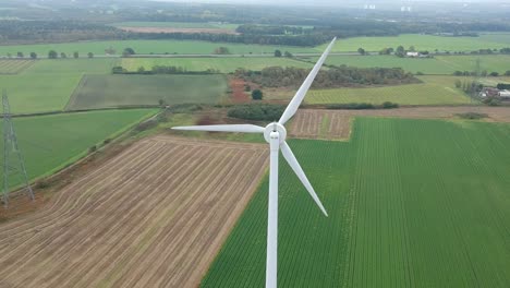 Toma-Aérea-Moviéndose-Hacia-El-Cierre-De-La-Turbina-Eólica-En-El-Campo-Británico