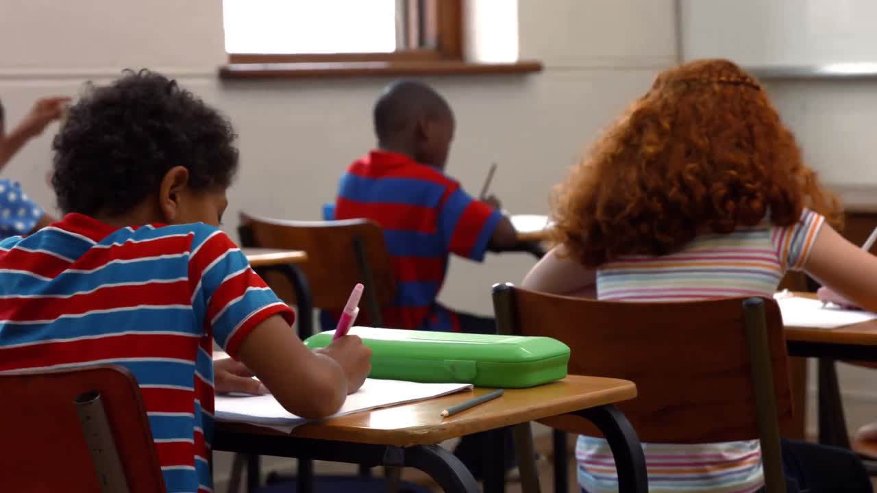 School children writing in classroom