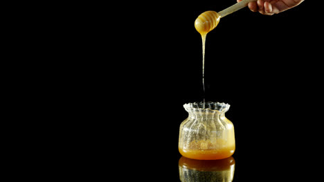 honey being poured into a jar 4k