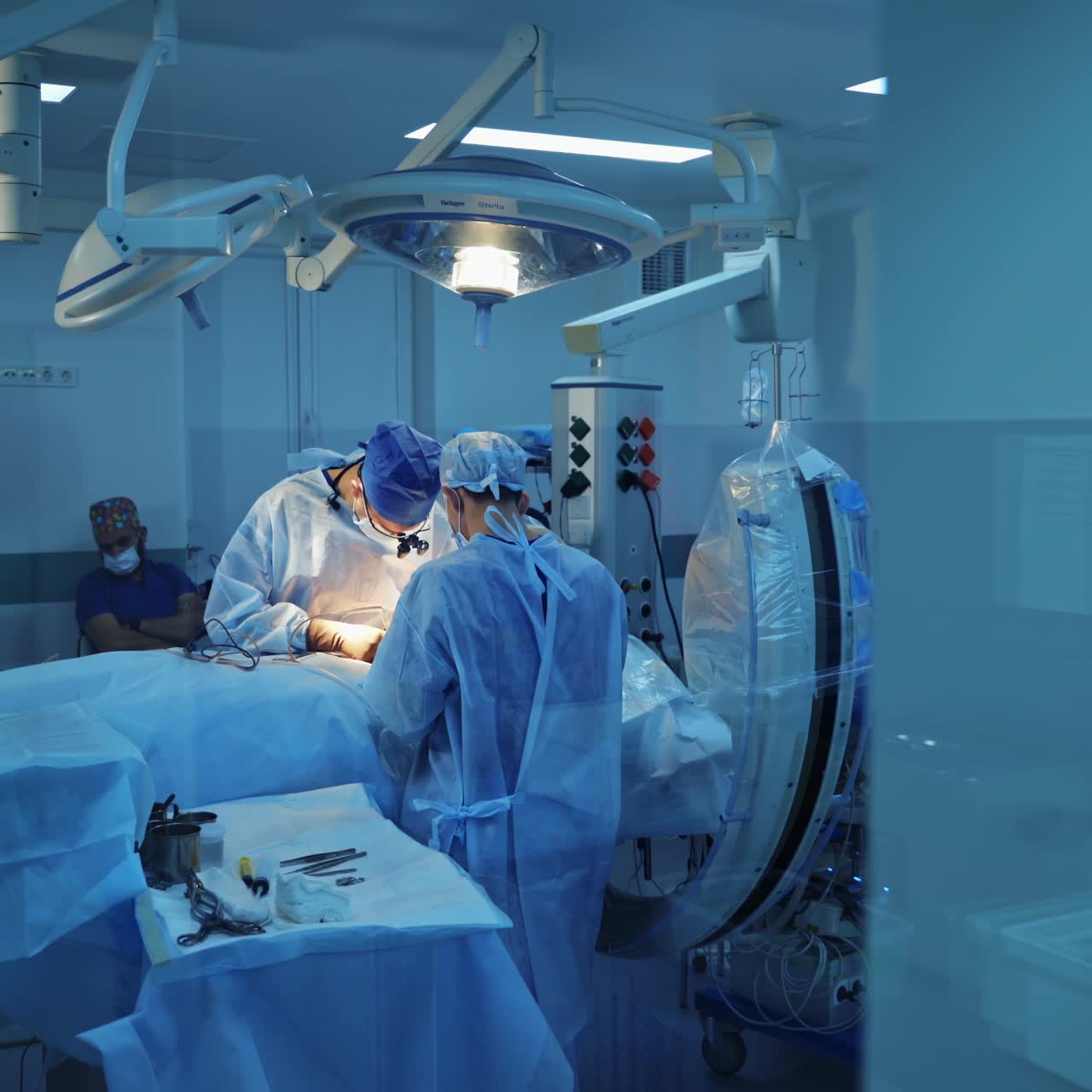 Surgical process in modern medical center. Operating theater. View through the small window into the operating room. Motion camera back.