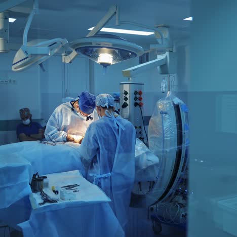 surgical process in modern medical center. operating theater. view through the small window into the operating room. motion camera back.