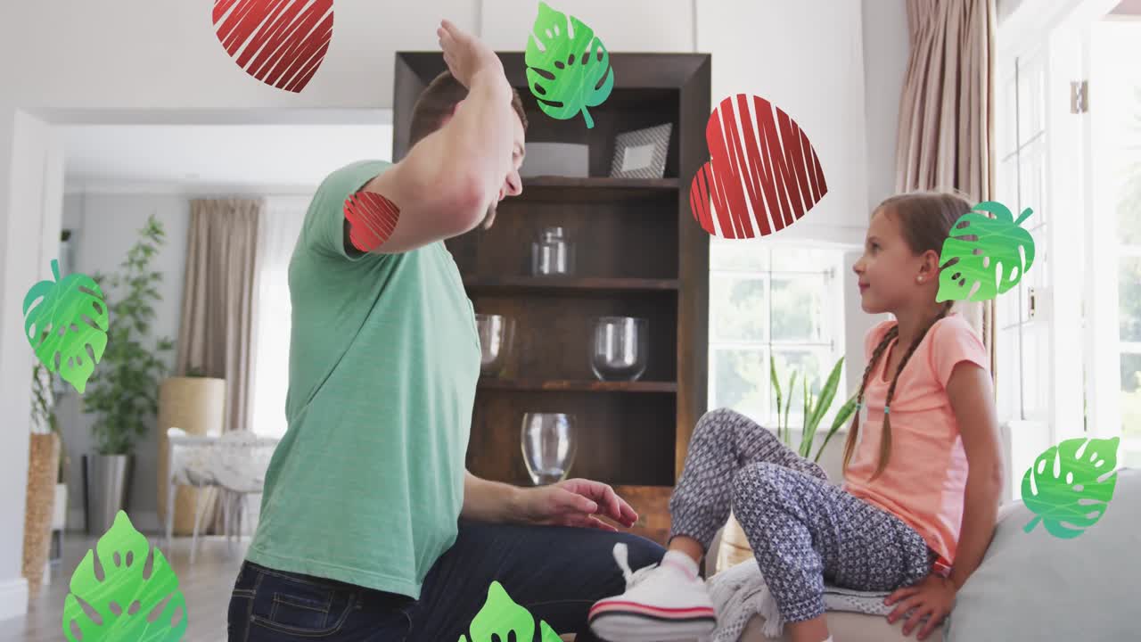 백인 아버지가 딸의 신발을  ⁇ 고 있는 잎과 심장의 애니메이션