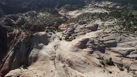 Aerial-View-of-Sandstone-Hills-and-Cliffs-in-Utah-Desert,-Bird-Flying-in-Front-of-Drone,-Yant-Flat-Hiking-Trail-USA