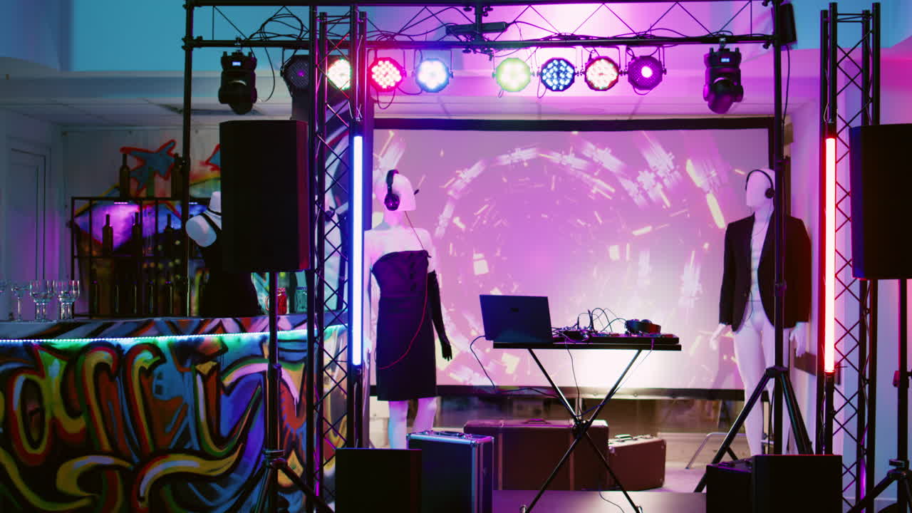 Stage setup with mannequins, laptop, sound system and lighting