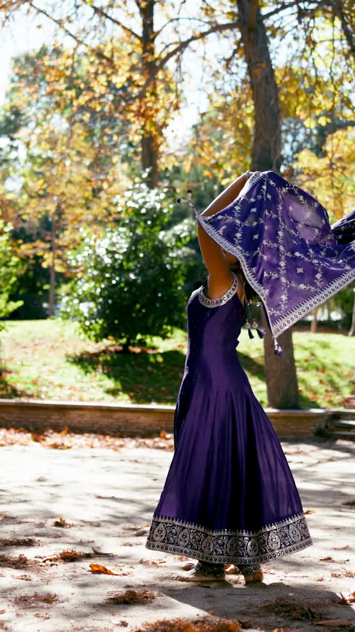 Mujer con vestimenta india en un parque durante el otoño