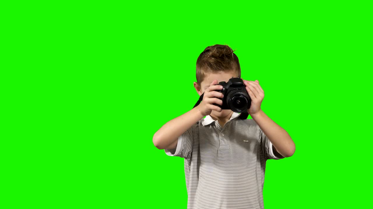 Little photographer takes photo at chroma key background