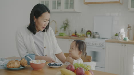 Happy Mother and Daughter Eating Breakfast