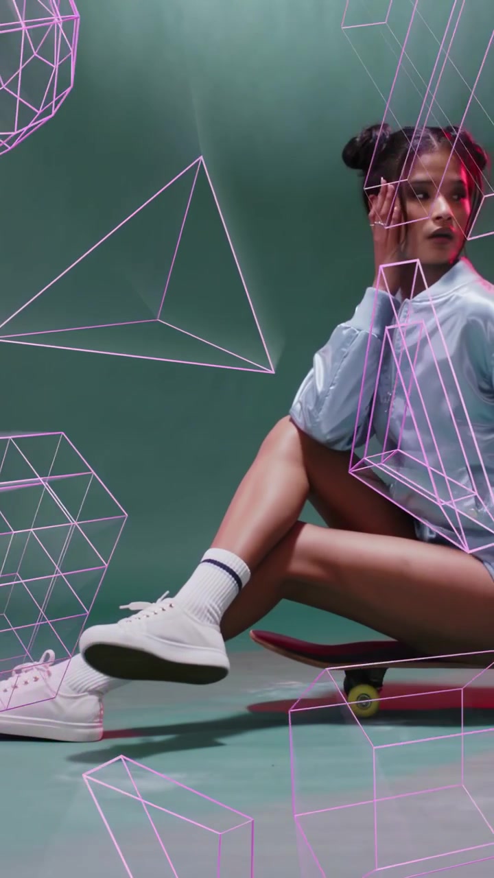 Sitting woman model adjusting neck and gaze on skateboard in studio, blue jacket, pink wireframes