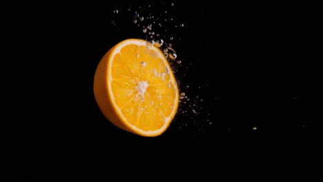 orange falling into water super slowmotion, black background, lots of air bubbles, 4k240fps