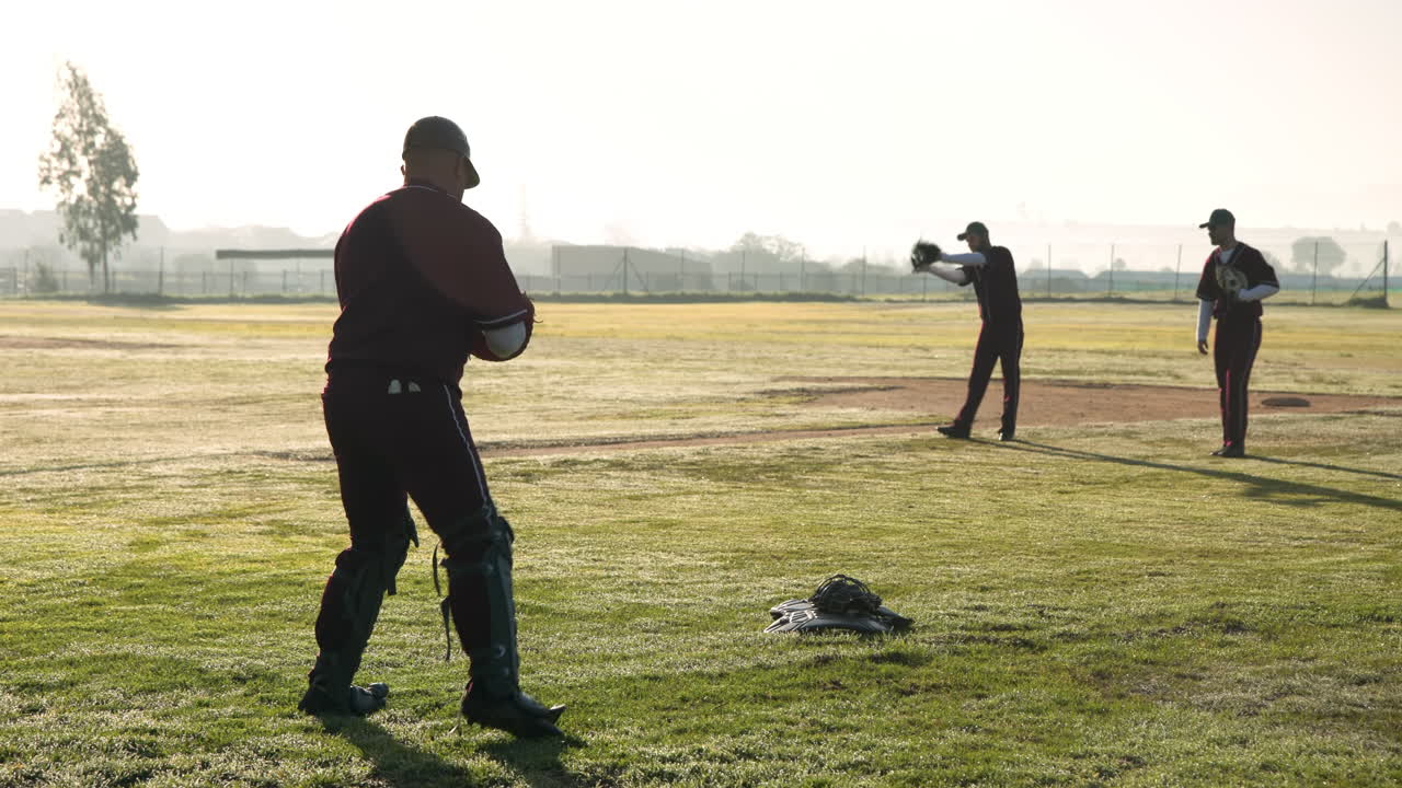 Playing baseball, catcher throwing ball on field during practice session