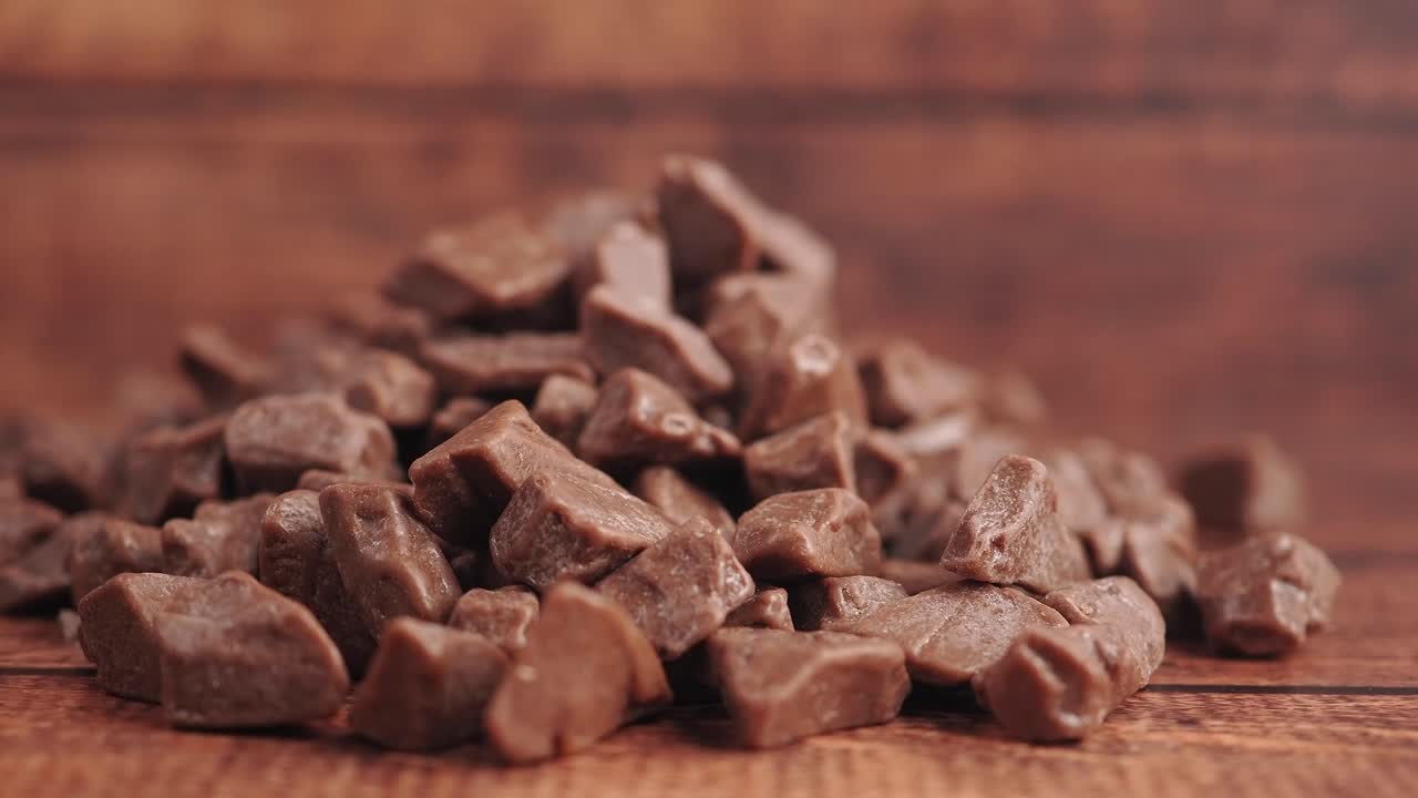 Pile of Milk Chocolate Chunks on Wooden Background