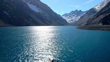 aerial dolly in view of a couple in a kayak on the laguna del inca, in the chilean andes, near the chile-argentina border