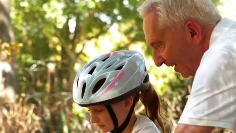 grandfather teaching his granddaughter to ride a bike