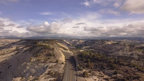 Drohnenschuss,-Der-über-Die-Gesamte-Amerikanische-Straße-State-Route-Scenic-Byway-12-Fliegt,-Mit-Einem-Weißen-Auto,-Das-Am-Nationaldenkmal-Grand-Staircase-Escalante-In-Utah,-USA,-In-4k-Vorbeifährt