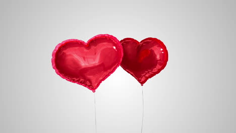 heart balloons floating against grey background