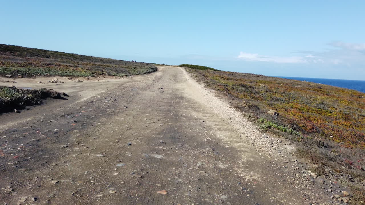 driving on a dusty coast road at the atlantic ocean in  portugal