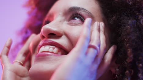 mujer biracial con cabello oscuro en luz azul y rosa, cámara lenta