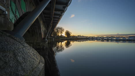 Timelapse-of-Carrick-on-Shannon-town-bridge-in-county-Leitrim-and-Roscommon-with-traffic,-people-and-moving-sunset-evening-clouds-on-river-Shannon-in-Ireland