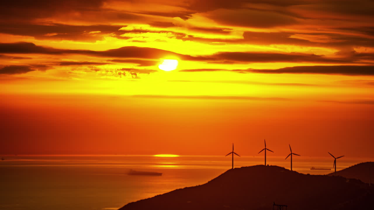 The beauty of nature is depicted in this time-lapse photograph of the sea and wind turbines during sunset in Malaga, Spain, showcasing Galax's elements