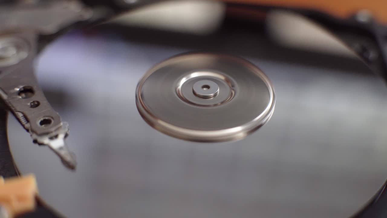 하드 디스크는 테이블 위에 놓여 있으며, 박이고 회전하는 디스크입니다.