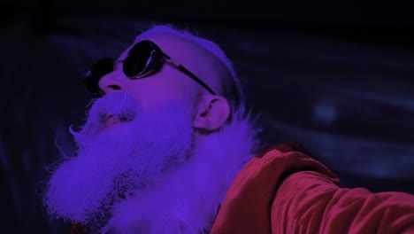 energetic excited santa claus dances, haves fun at modern new year holiday party