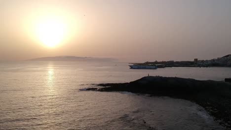 A-drone-tilt-down-shot-of-a-transport-boat-leaving-port-at-Costa-De-Las-Americas-with-birds-flying