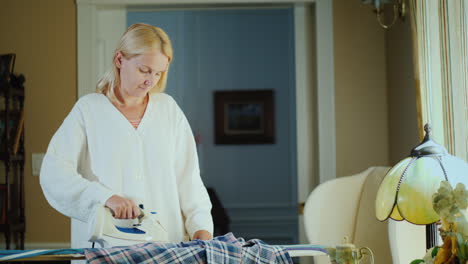 Middle-Aged-Woman-Ironing-Clothes-On-An-Ironing-Board