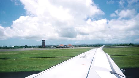 shot of the wing of plane while the plane prepares to take off during a sunny day taken from inside the plane