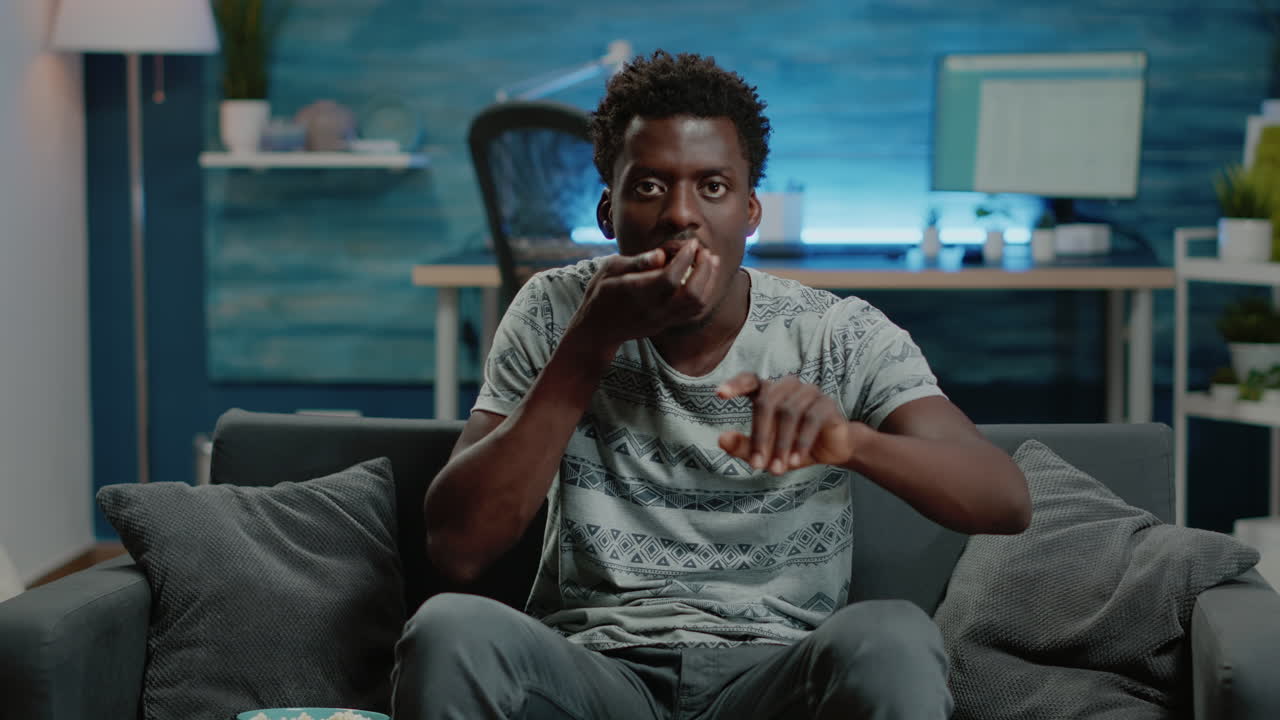 African american man cheering at football game on television