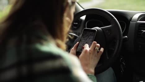 Crop-driver-using-navigation-app-on-smartphone-in-car
