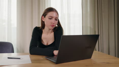 mujer trabajando en una computadora portátil en casa