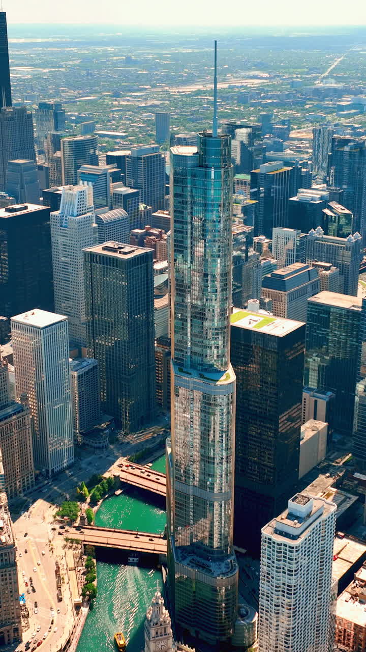 Glass skyscrapers in downtown Chicago. Aerial view of the Chicago River with bridges and streets. Michigan Avenue. Vertical video