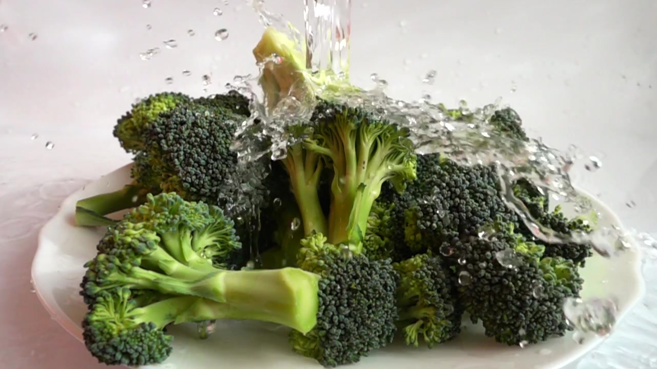 Ripe broccoli and spray. Slow motion.