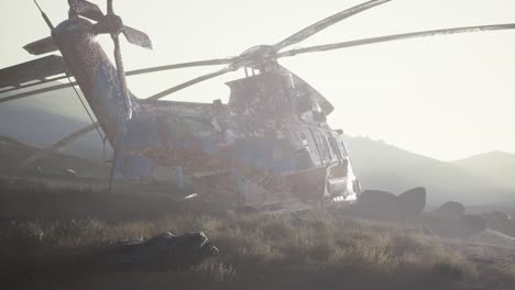 old rusted military helicopter in the desert at sunset