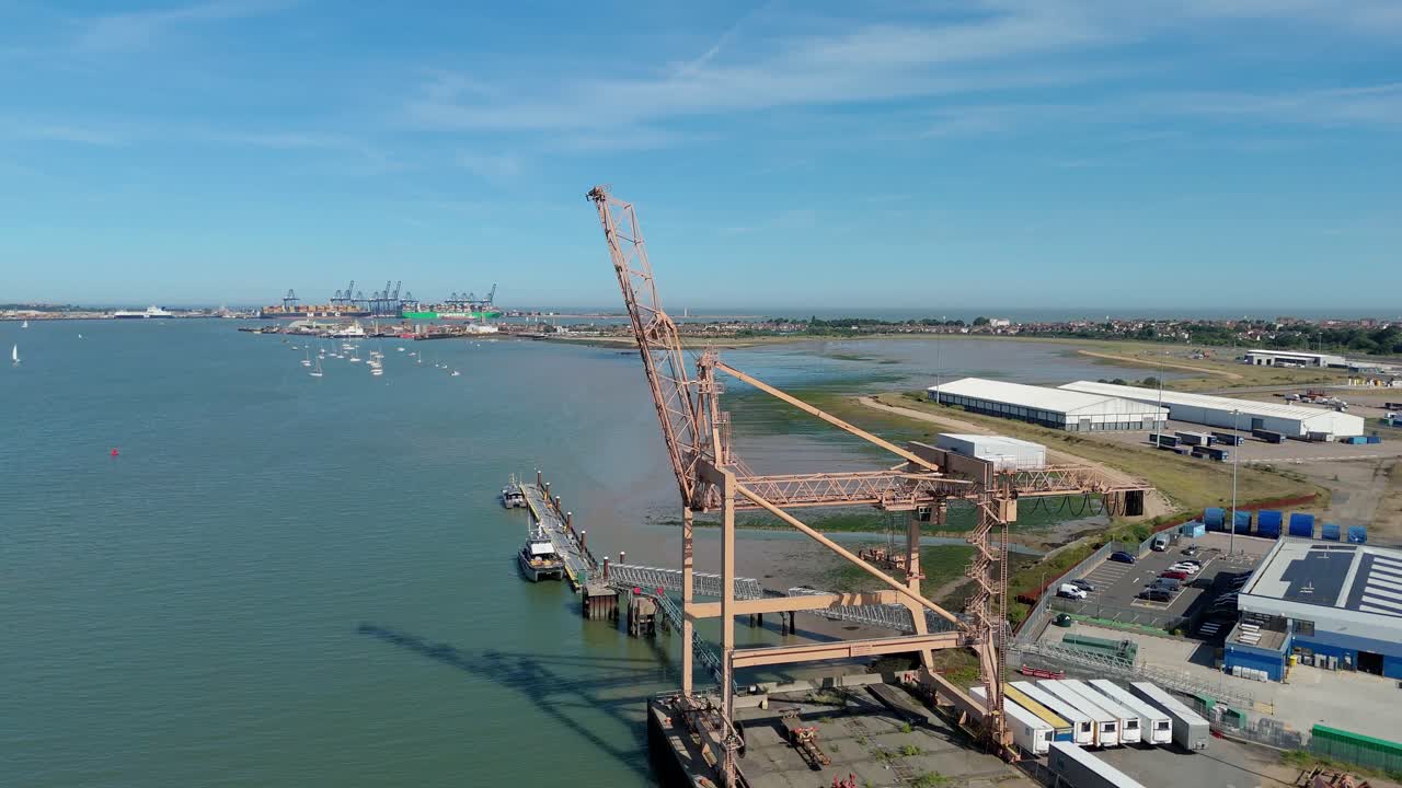 Aerial drone view of Harwich town and harbour with cranes, cargo port and coastline in view on a bright sunny day in seaside England, UK