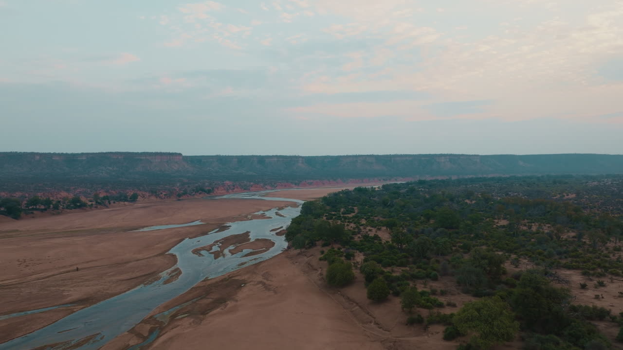 Aerial drone view of Runde River and Chilojo Cliffs in Gonarezhou, Zimbabwe, evening, after sunset, haze