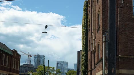 Un-Par-De-Zapatos-Atados-Juntos-Colgando-De-Una-Línea-Eléctrica-En-Seattle,-Washington-En-Un-Cálido-Día-Soleado-De-Verano