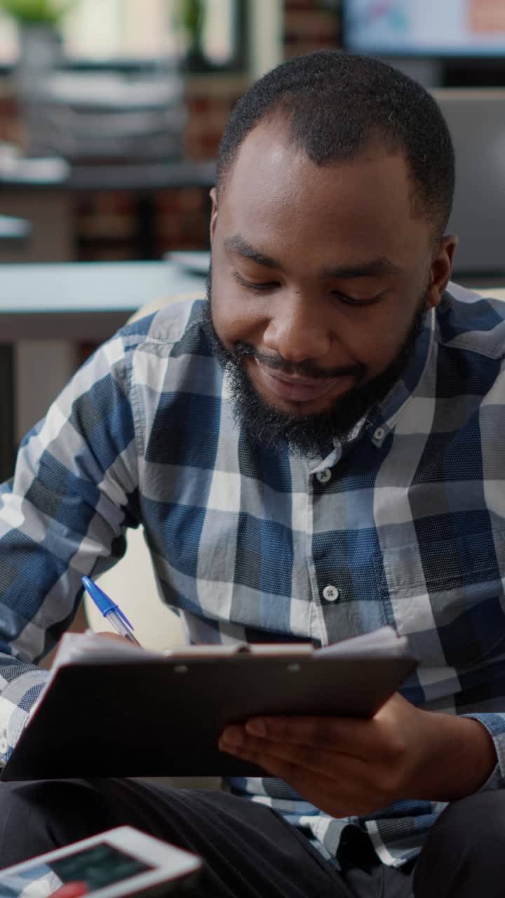Man working from home with laptop and clipboard