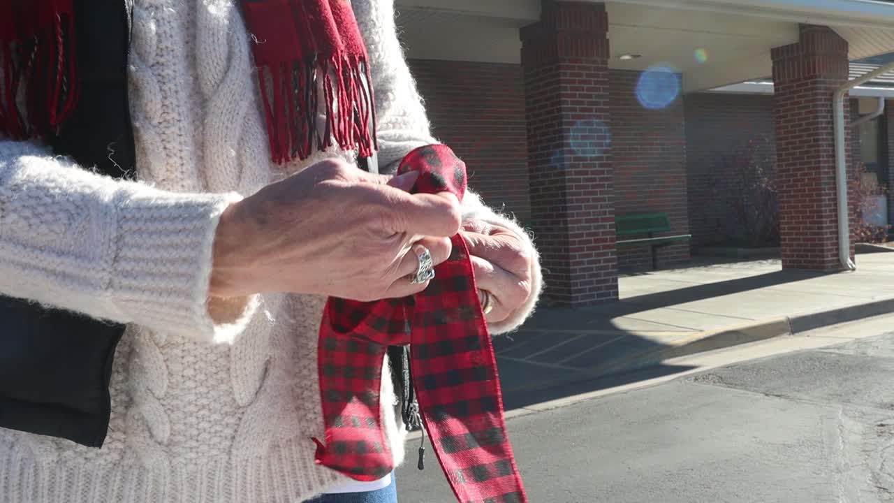 элегантная женщина завязывает бант в социально дистанцированной мастерской по украшению пандемий