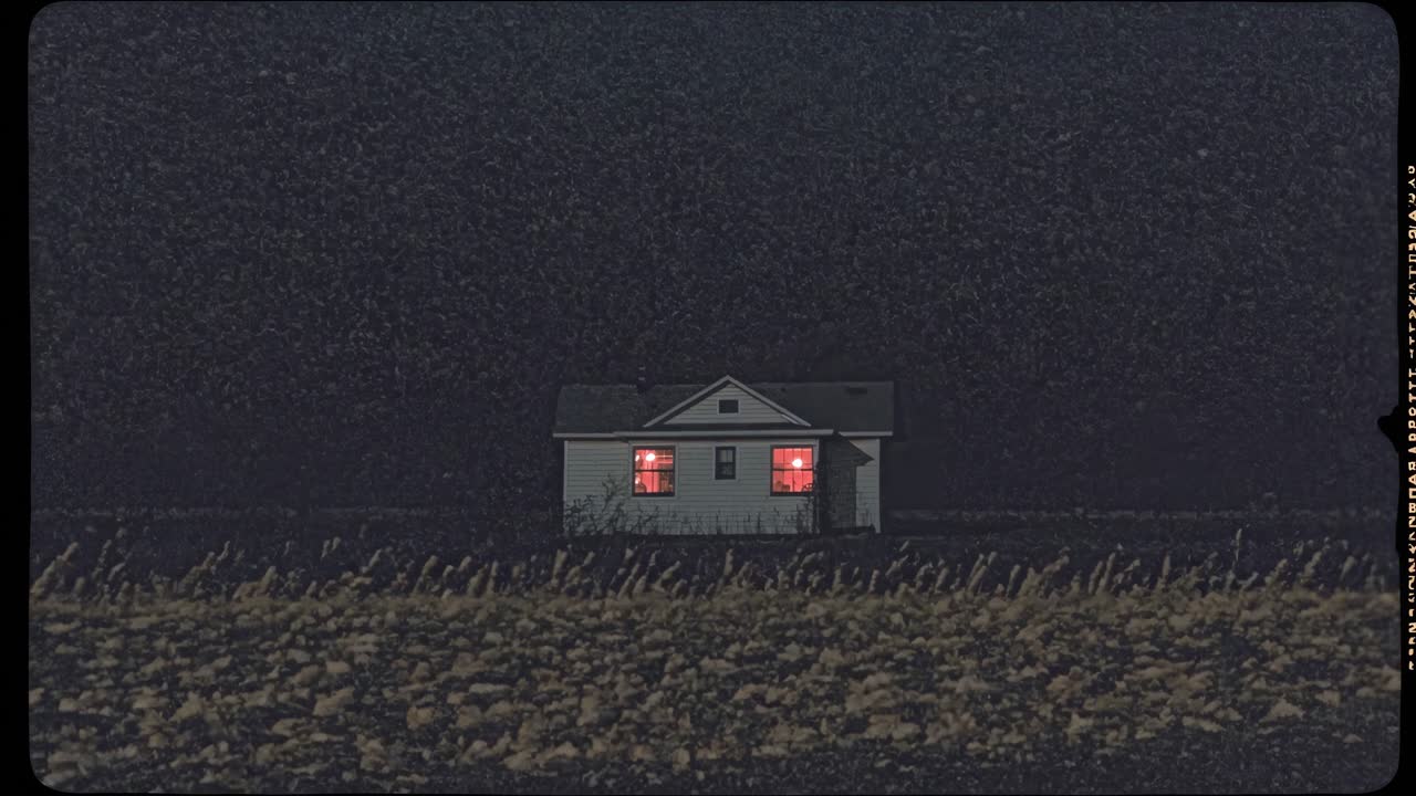 Glowing windows of an isolated house in a dark night illuminating a field, creating a mysterious and eerie atmosphere with a vintage film aesthetic