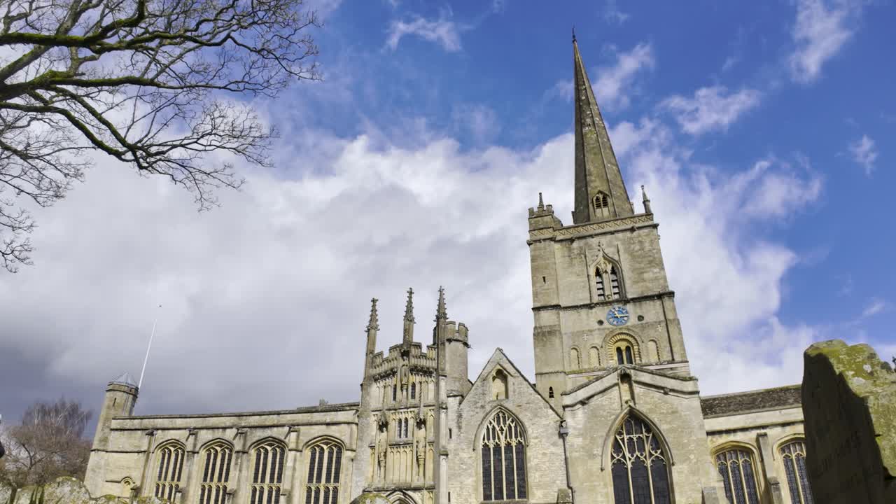 Church of St John the Baptist with the graveyard in the foreground, Cotswolds, Burford, England, United Kingdom - March 2024
