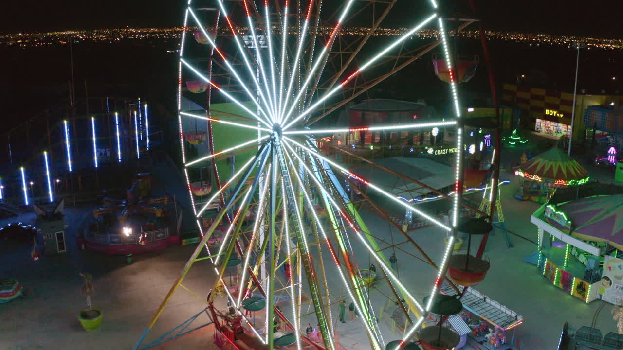 Drone of a stationary carousel with no people at a funfair with blinking colorful lights
