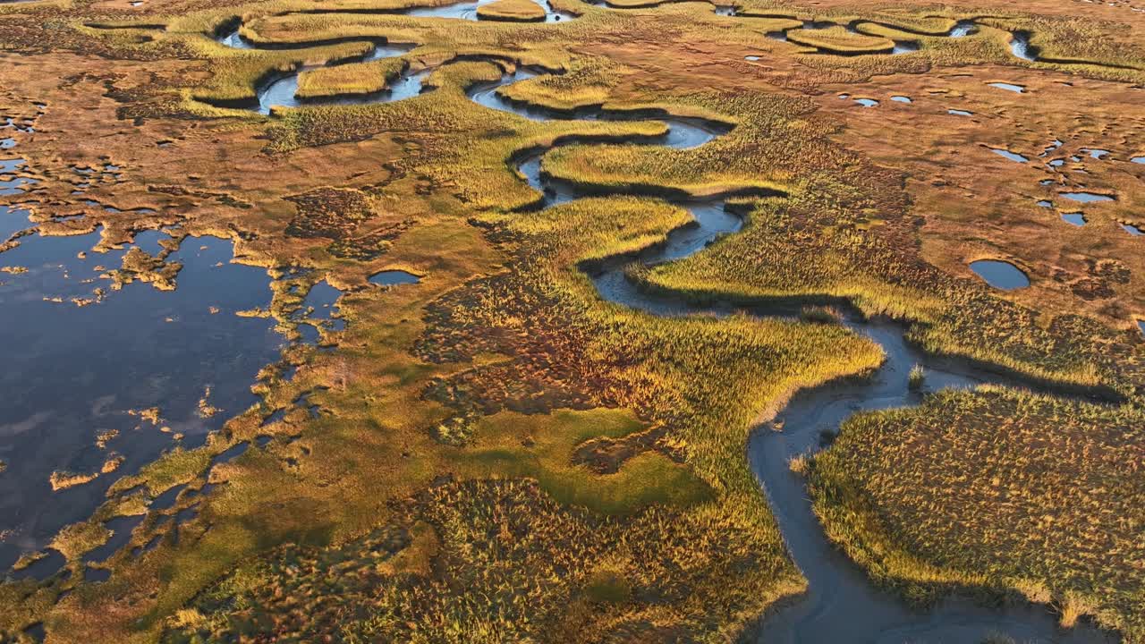 Aerial top down shot of Salt Marsh at sunrise. Cape Cod, Barnstable Massachusetts in autumn season. Colorful plants in salt marsh during fall season.