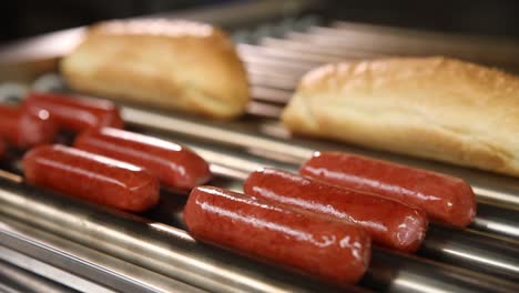 hot dogs and buns on a commercial grill