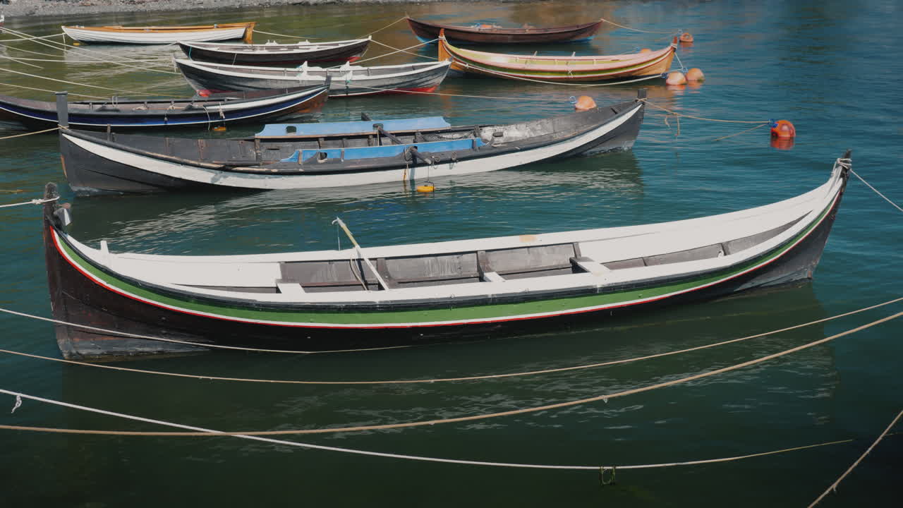 varios pequeños botes de madera amarrados en la orilla de un video de 4k de pueblo de pescadores