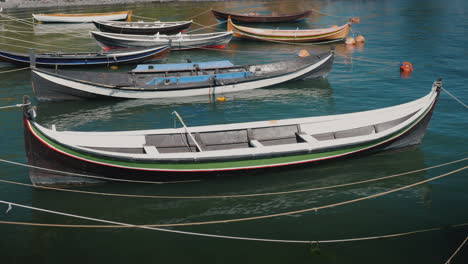 several small wooden boats moored at the shore of a fishing village 4k video