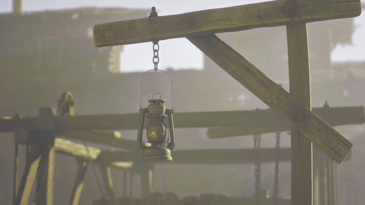 Vintage lantern hanging in an old wooden structure during early morning light