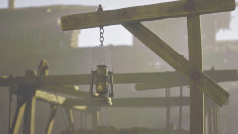vintage lantern hanging in an old wooden structure during early morning light